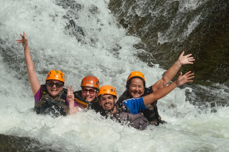 Group body rafting through whitewater in a private El Yunque canyon