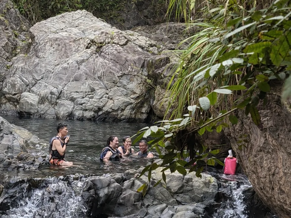 Group in life jackets swimming in a waterfall pool on the south side of El Yunque